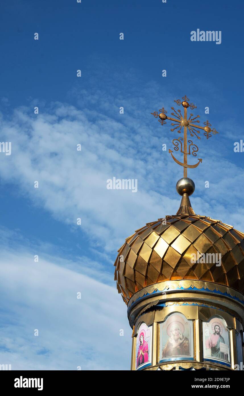 The golden dome of an Orthodox village chapel against a blue sky. God. Believers. Vera. Worship service. Copy space for text. Stock Photo