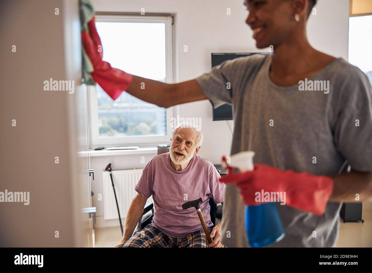 Volunteer helping a disabled person clean his home Stock Photo Alamy