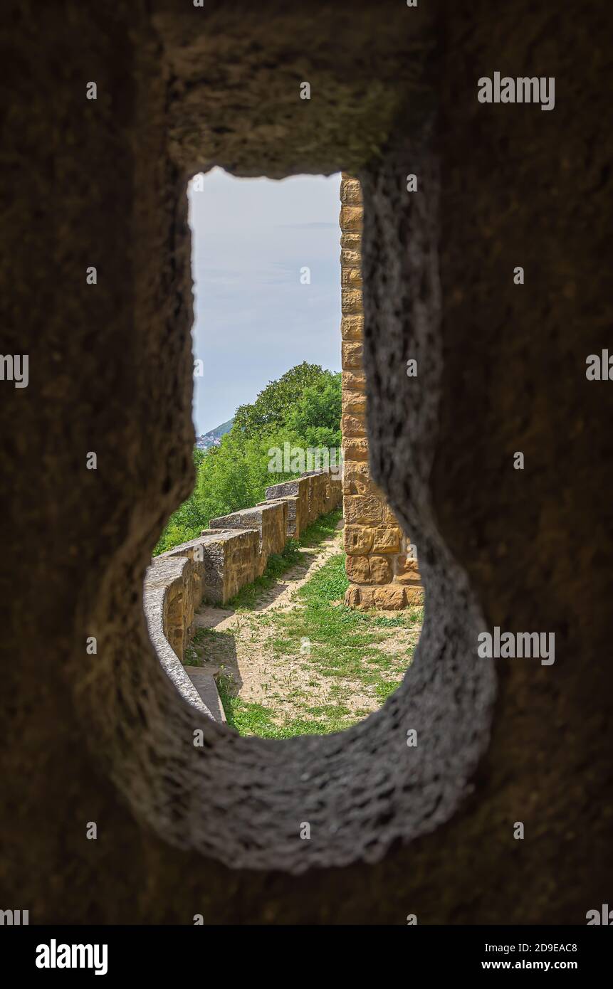 View through a loophole in a castle wall to parts of the outer castle