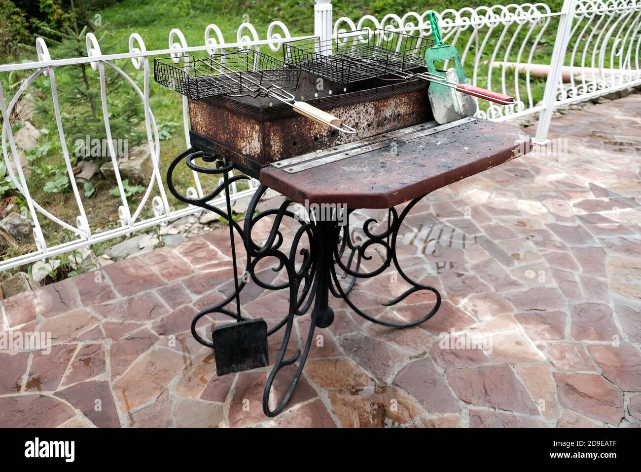 Barbecue grill in the backyard outside. Empty dirty kitchen equipment after cooking dinner. Black grill with charcoal. No bbq during global pandemic Stock Photo