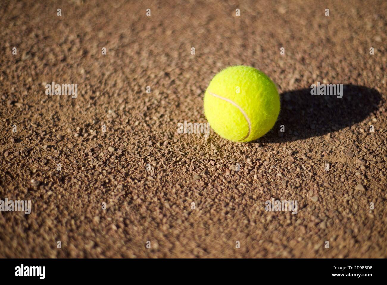 Tennis ball on a clay court. Copy space for text. Stock Photo