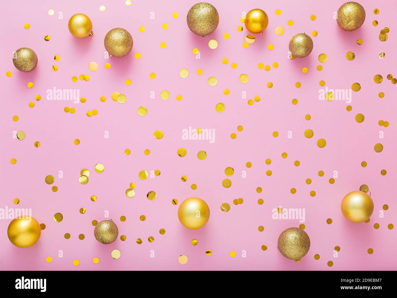 Christmas gold festive decor balls, confetti on pink background. Top view copy space Stock Photo