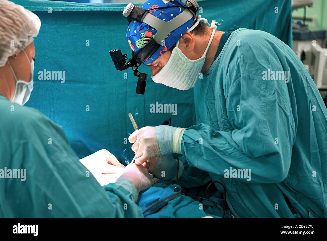 Surgeon and his assistant performing cosmetic surgery on nose in
