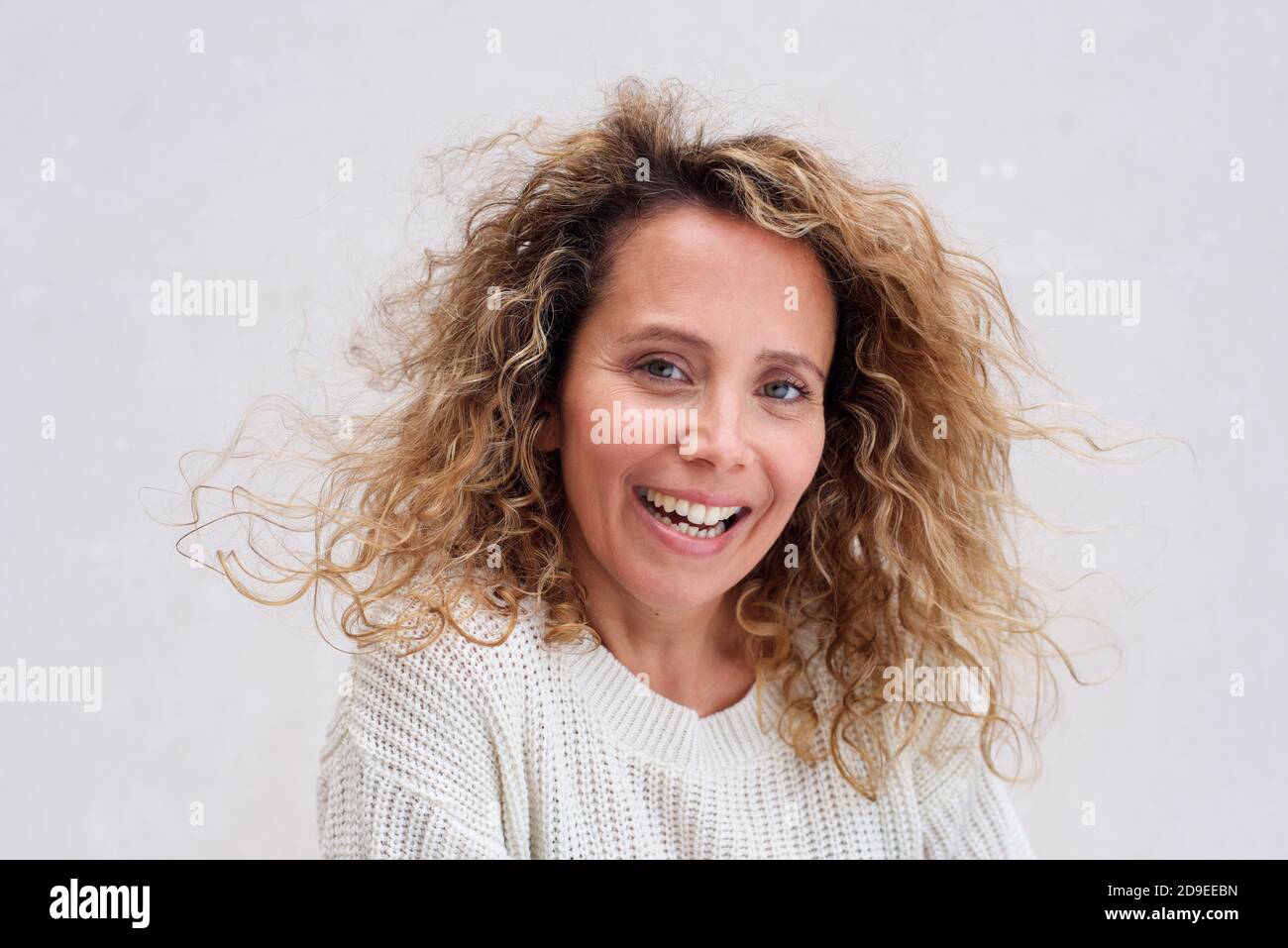Close up portrait happy older woman with curly hair laughing against ...
