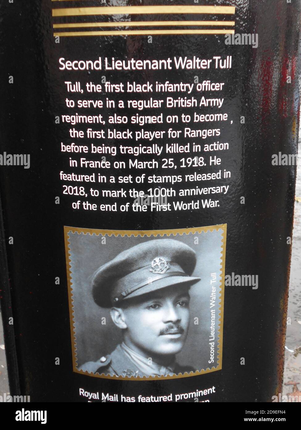 This Royal Mail post box, in Glasgow, has been painted black and gold to celebrate Black History month, October 2020. It is a tribute to Walter Tull, who was the 1st black officer in the regular British Army. He was also signed up to play for Rangers football team before being killed in action, in France, on the 25th March 1918. The inscription, seen here, tells you about Walter Tull. 2020. ALAN WYLIE/ALAMY© Stock Photo