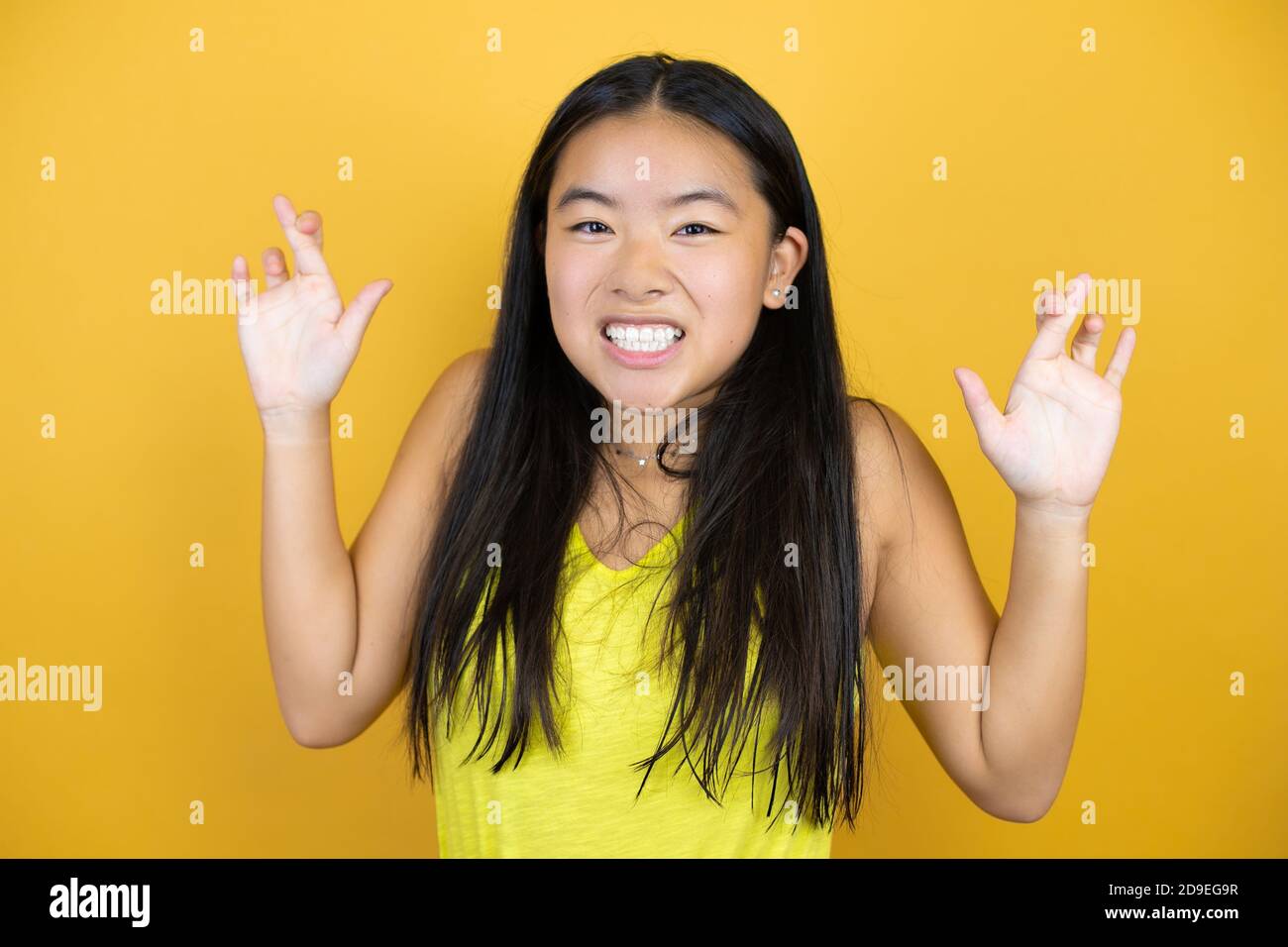 Young beautiful asian woman over yellow isolated background gesturing ...