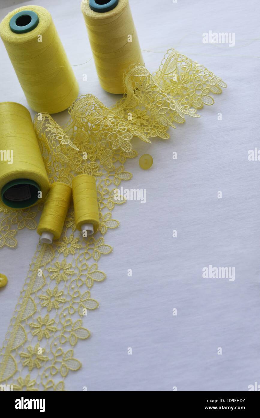 Needlework. Sewing. Yellow threads Yellow lace ribbon. Vertical format