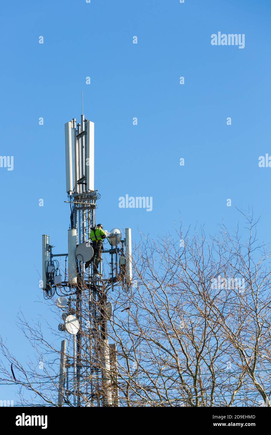 Telecoms engineer working at height on telecommunications mast, hamstreet, ashford, kent, uk Stock Photo