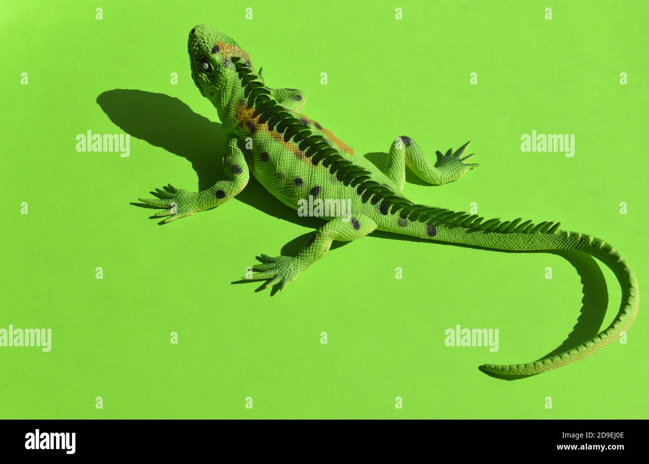 Iguana on a green background. Toys for kids. Play with children. Copy space. Horizontal format. Stock Photo