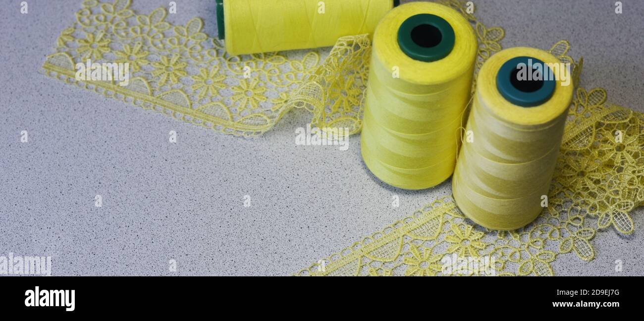 Needlework. Yellow. Sewing braid lace buttons. Copy space. Horizontal