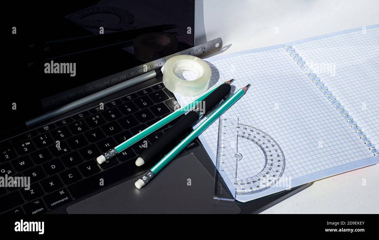 Stationery on laptop keyboard. Modern opportunities for work and study. Stock Photo