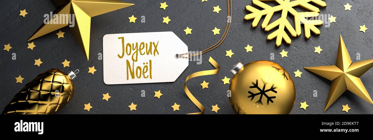 Christmas - Gift Tag with the French Merry Christmas message 'Joyeux Noël' on a black stone background with gold colored christmas ornaments around. B Stock Photo