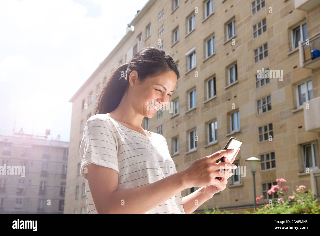 Close up portrait young asian woman looking at mobile phone in city Stock Photo