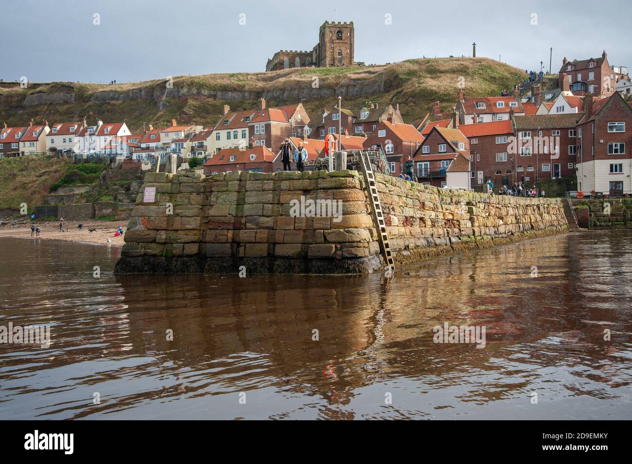 A view of the stone jetty with the abbey in the background. Whitby Harbour, Whitby, Yorkshire, England. Stock Photo