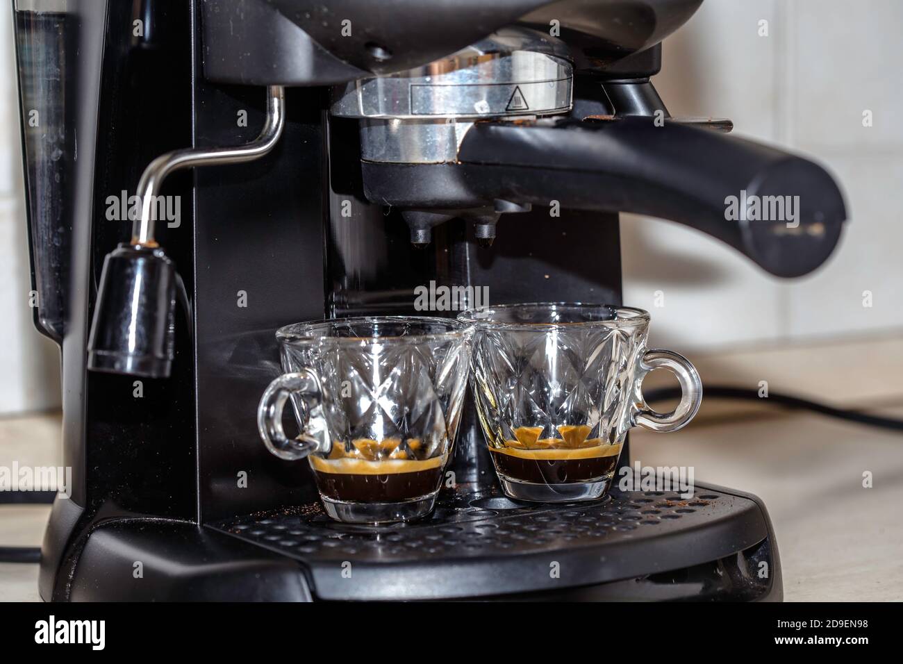 Process of making two espresso shots using espresso machine. Italian coffee. Stock Photo
