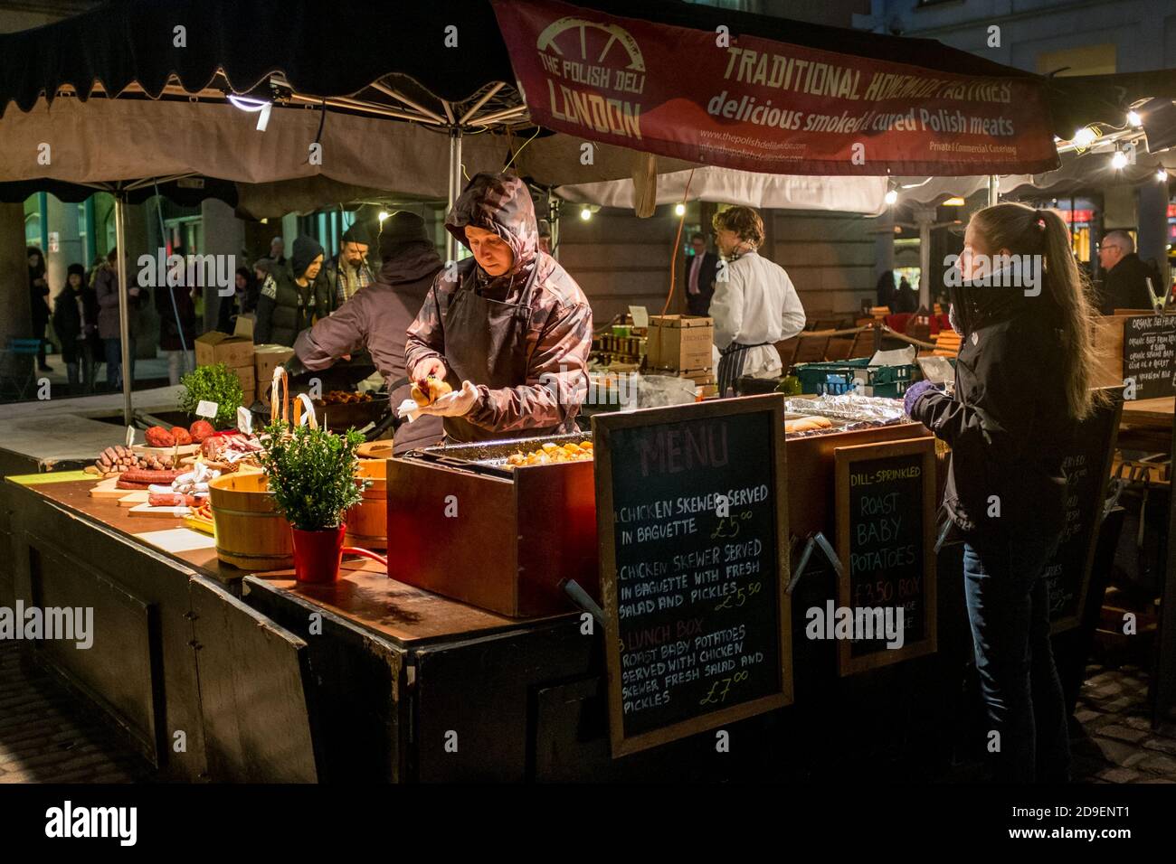 Staff on a traditional Polish food stall serving customers in Covent Garden just after dusk.. 05 February 2015. Photo: Neil Turner Stock Photo