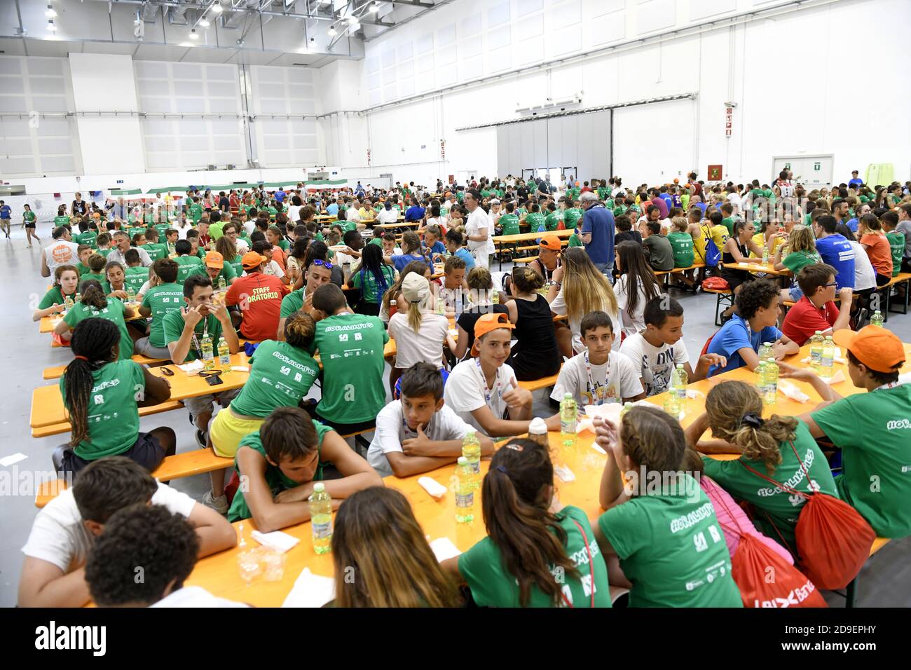 Hundreds of kids seating for lunch on a summer camp canteen , in Milan. Stock Photo