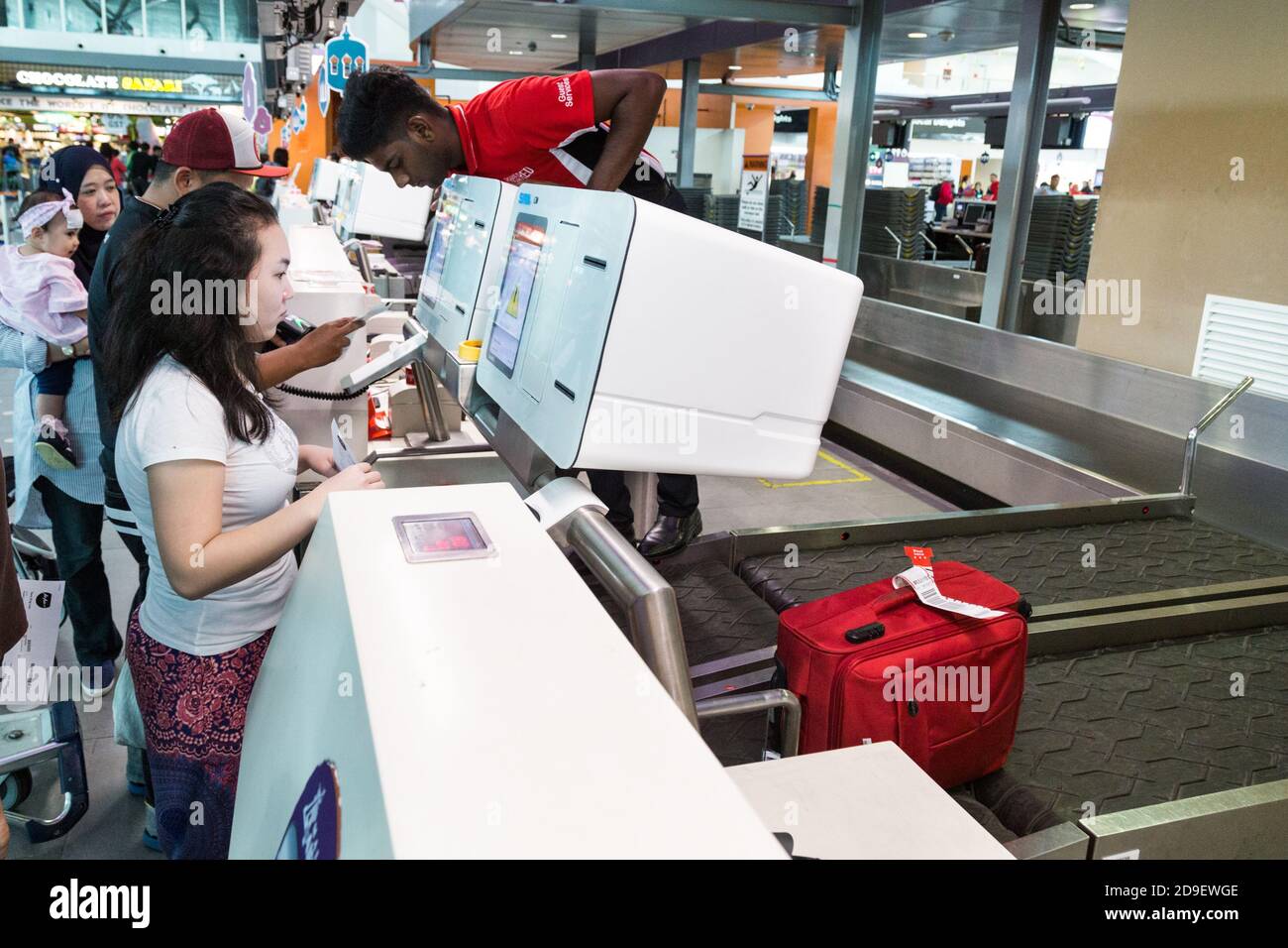 Passenger using convenient self checkin luggage bag machine at KL