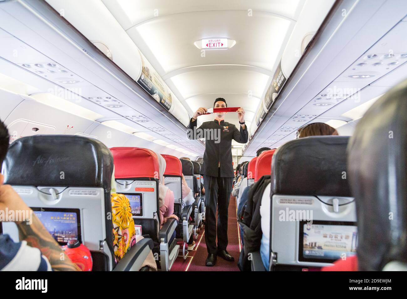Series of steward demonstrating safety prosedure prior to commercial Airasia airline flight took off. Stock Photo
