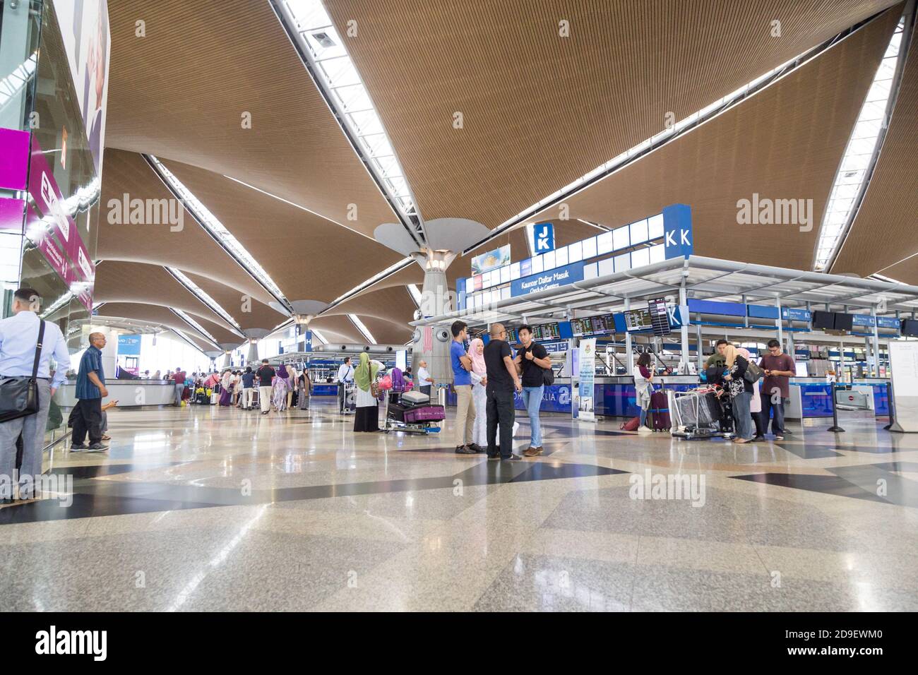 Travelers walking around identifying their flights check-in counters at ...