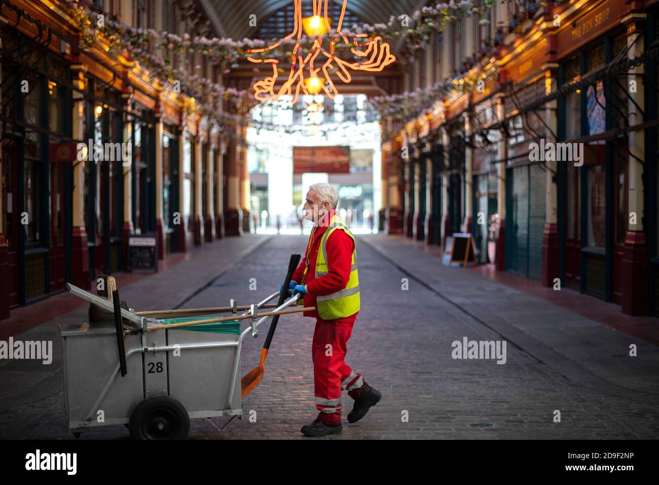 A street cleaner walks through an empty Leadenhall Market in London at