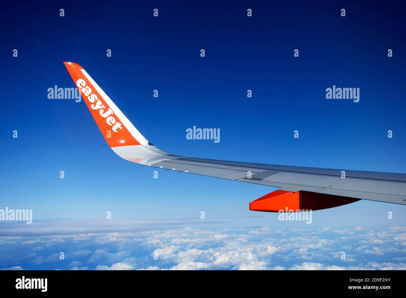 easyJet logo, on the wing of an aeroplane in flight, against a strong blue sky Stock Photo