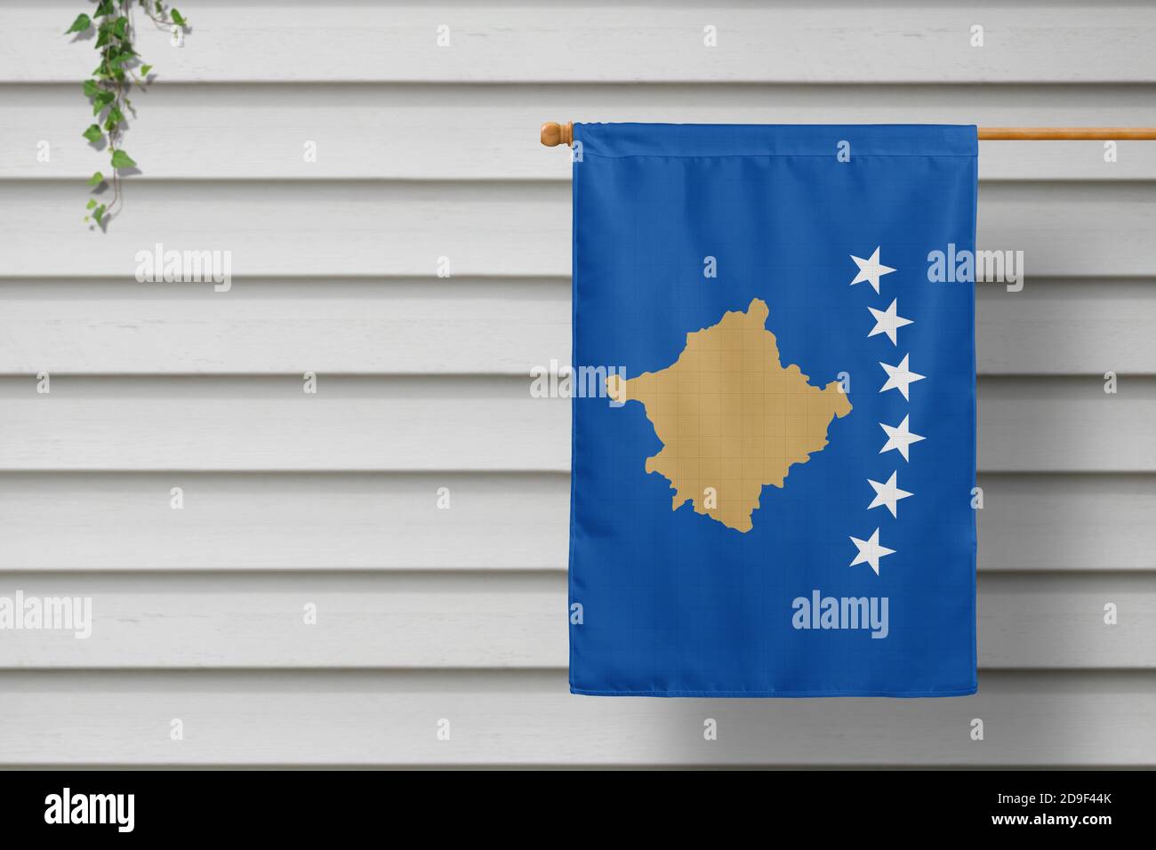 Kosovo national small flag hangs from a picket fence along the wooden wall in a rural town. Independence day concept. Stock Photo