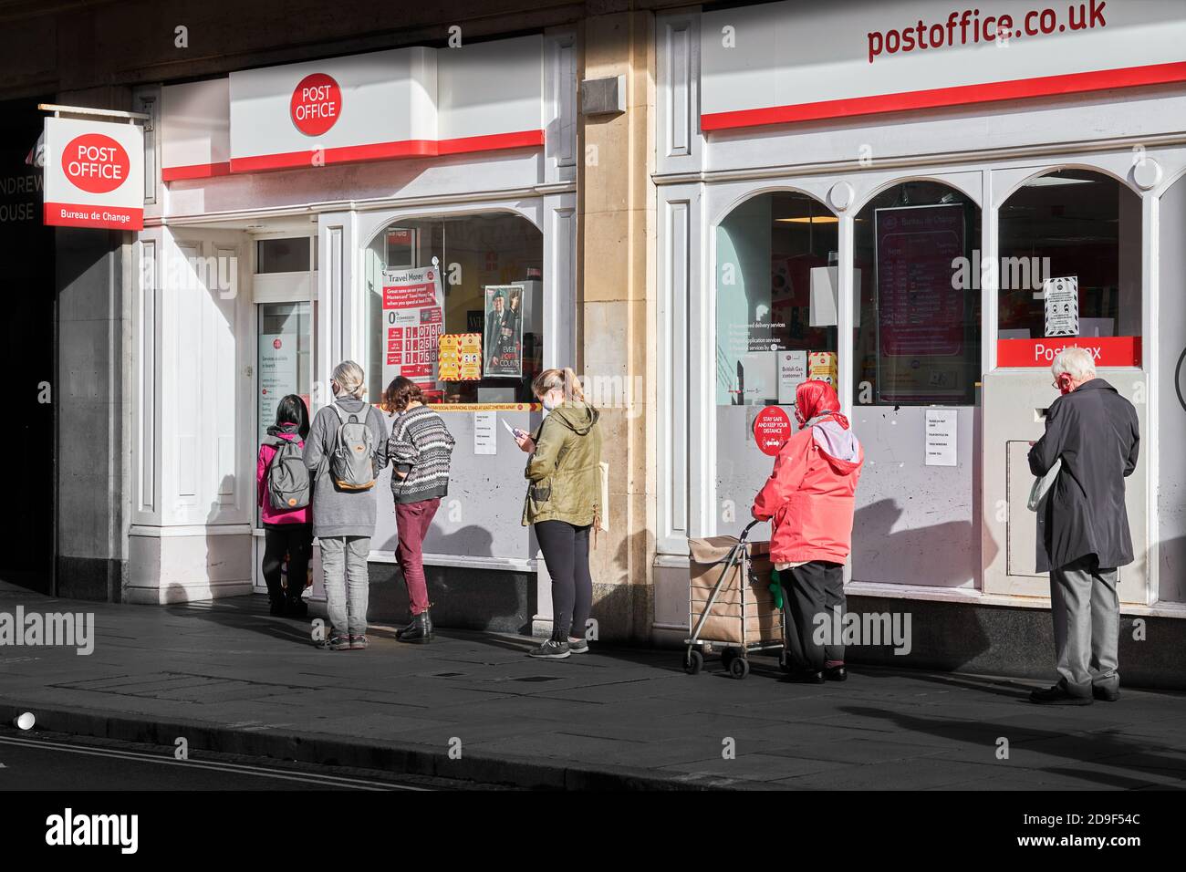 Customers form an orderly distanced queue outside the Post Office, Cambridge, England, during the coronavirus crisis, November 2020. Stock Photo