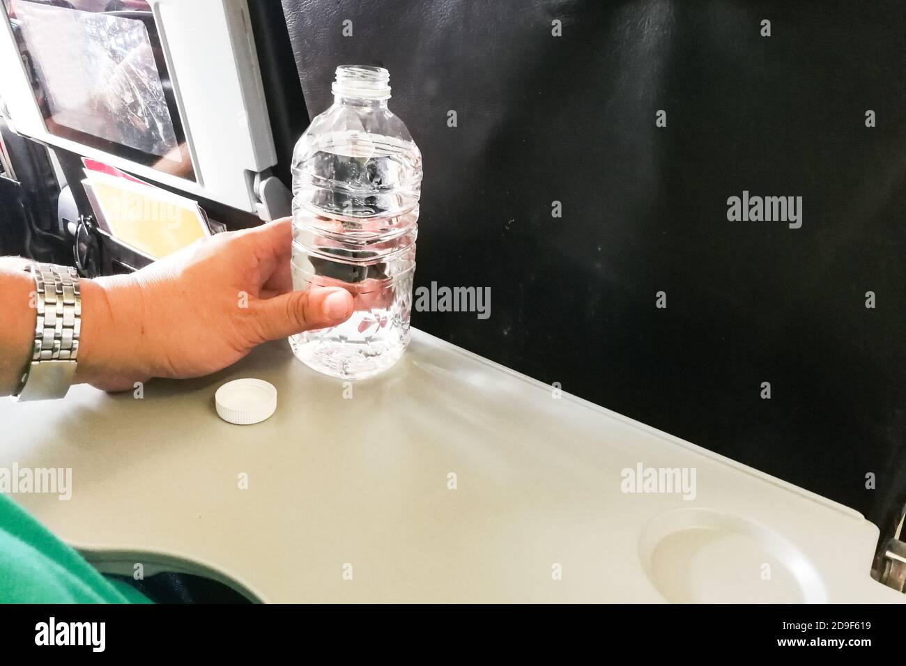 Plastic water bottle opened on an aircraft under cabin pressure and crushed  by air pressure on landing UK Stock Photo - Alamy