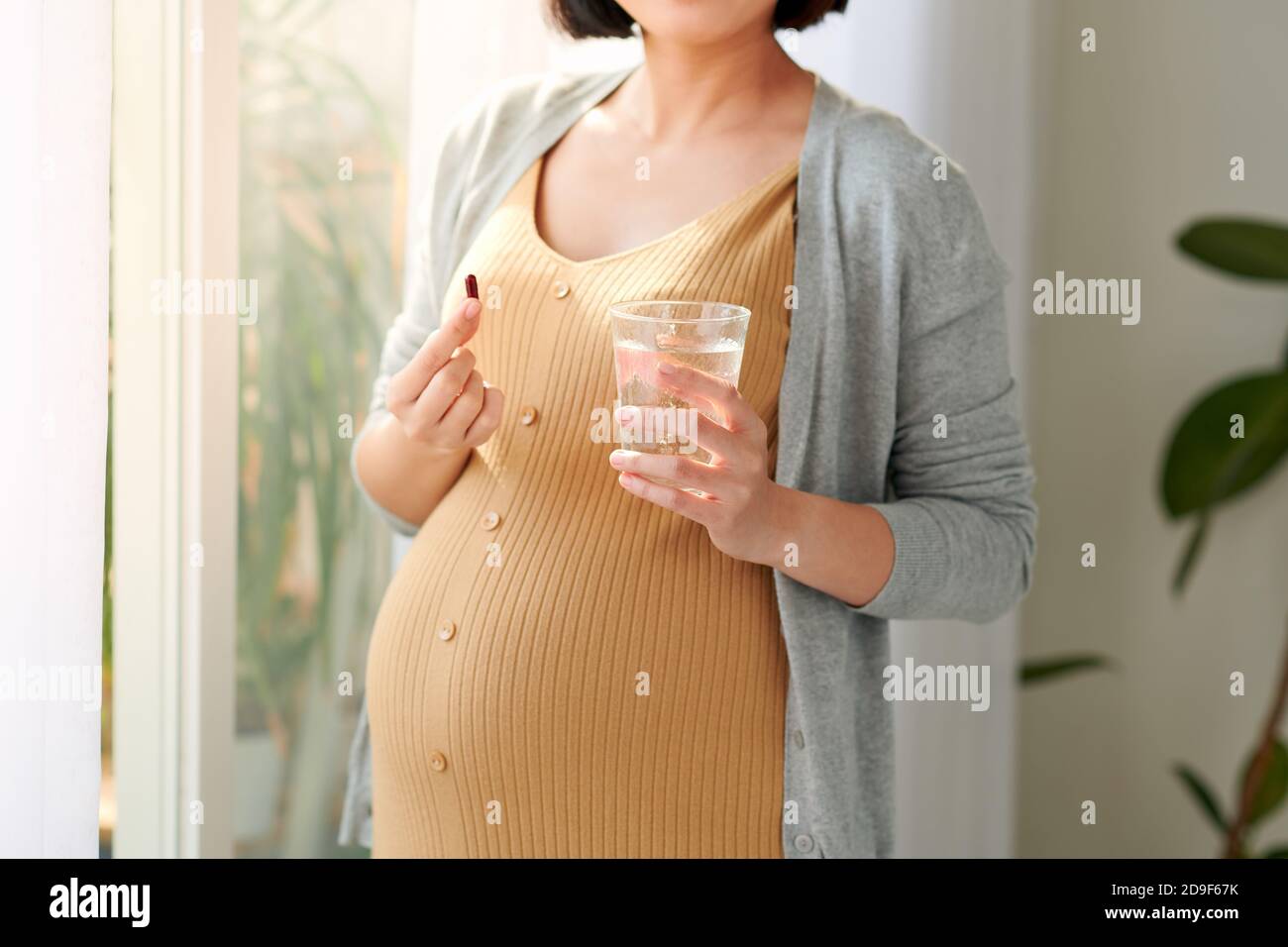 Pregnant woman taking vitamin pill Stock Photo Alamy