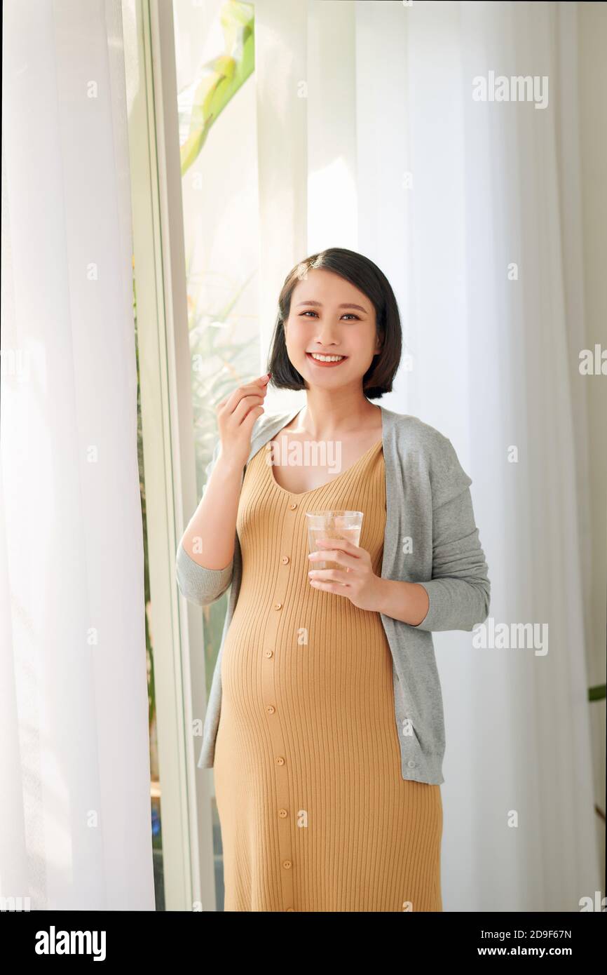 Pregnant woman taking vitamin pill Stock Photo Alamy