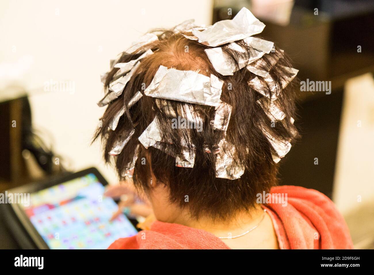 Hair wrapped with aluminum foil during chemical color hair dye Stock