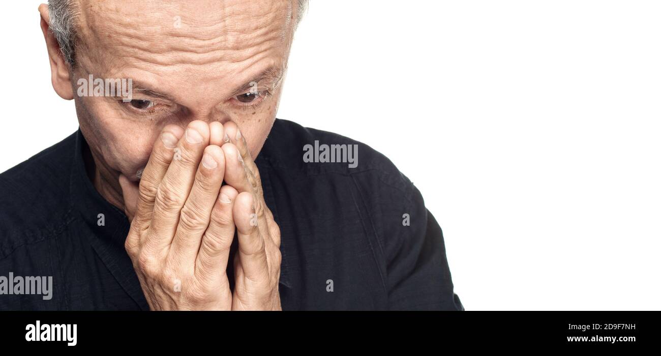 Elderly man covers his face with hand isolated on white background with ...