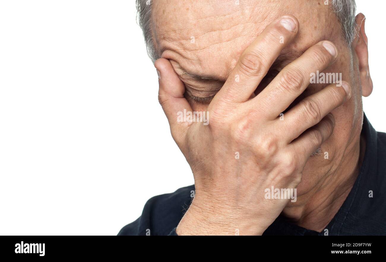 Pain. Elderly man covers his face with hand isolated on white ...