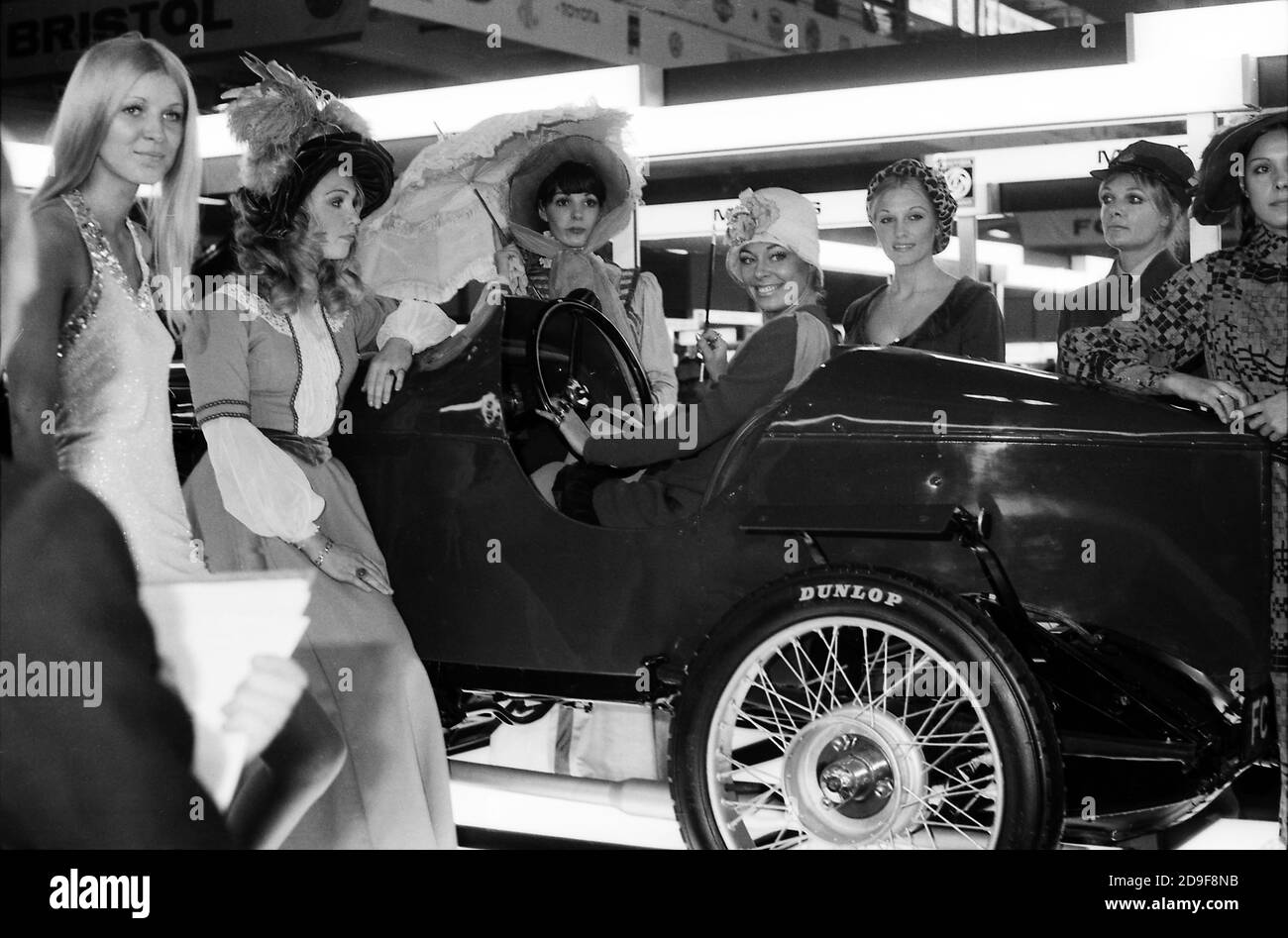 Seven models in period dress pose for photo around a veteran sports ...
