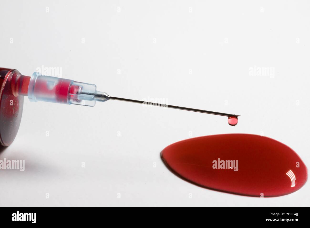 Hypodermic needle with a drop of blood on a white background Stock Photo