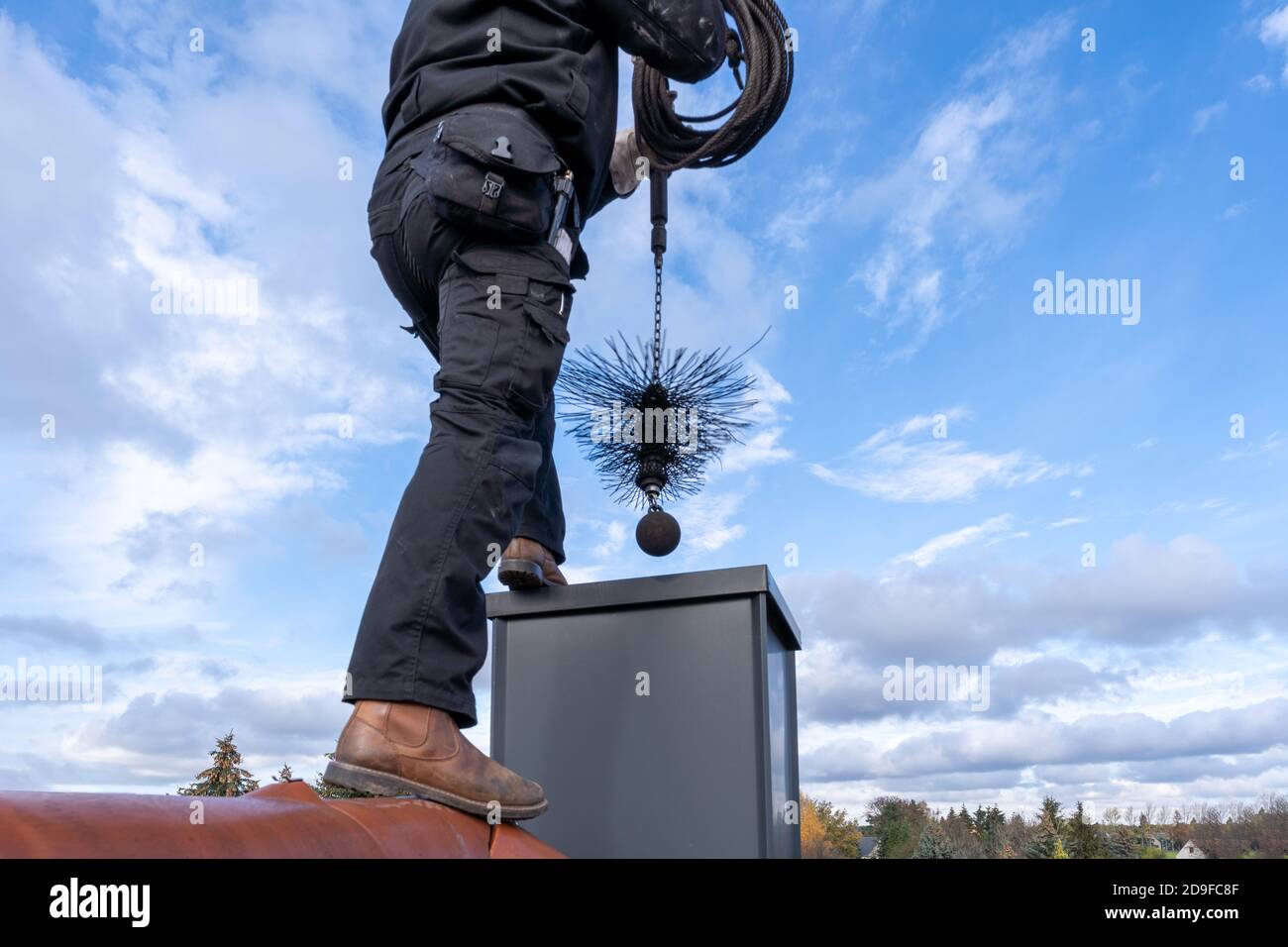 chimney sweep with stovepipe hat upon the roof Stock Photo