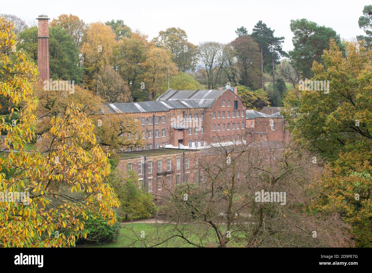 Quarry bank Mill historic cotton mill 1784 , Styal, Cheshire, UK. Autumn day looking through trees Stock Photo