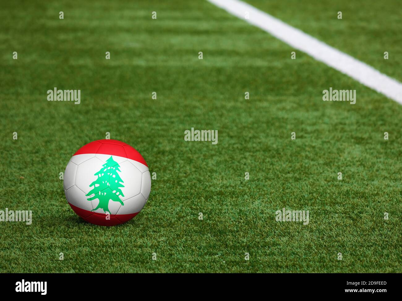 Lebanon flag on ball at soccer field background. National football