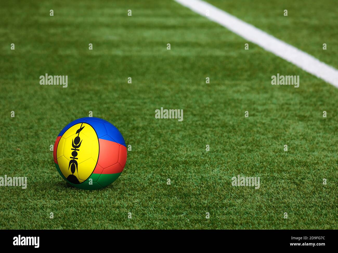 New Caledonia flag on ball at soccer field background. National