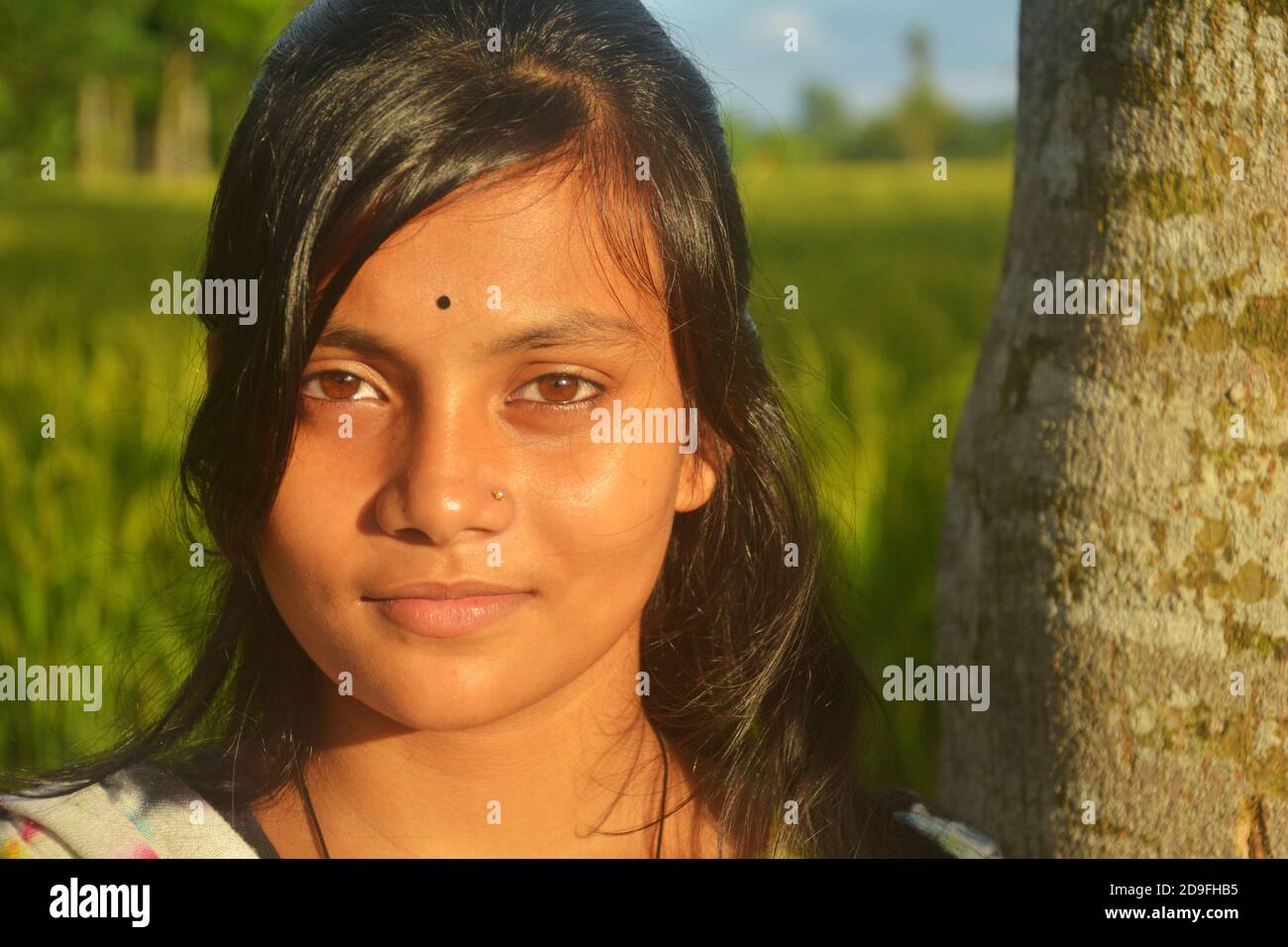 Close up of an Indian teenage girl wearing nose pin bindi on forehead with long dark hairs, selective focusing Stock Photo