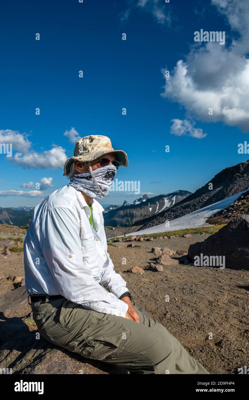 Man wearing a hiker's mask in the mountains Stock Photo
