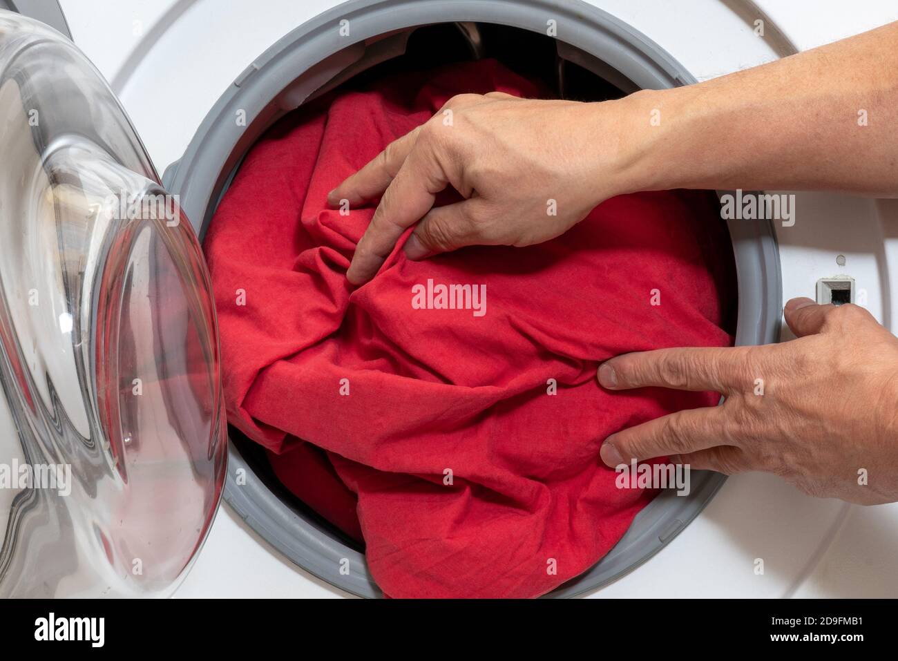 Loading bed linen into a household washing machine Stock Photo Alamy