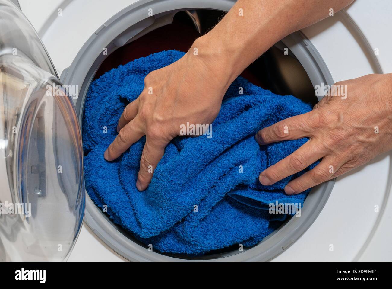 Loading bed linen into a household washing machine Stock Photo Alamy