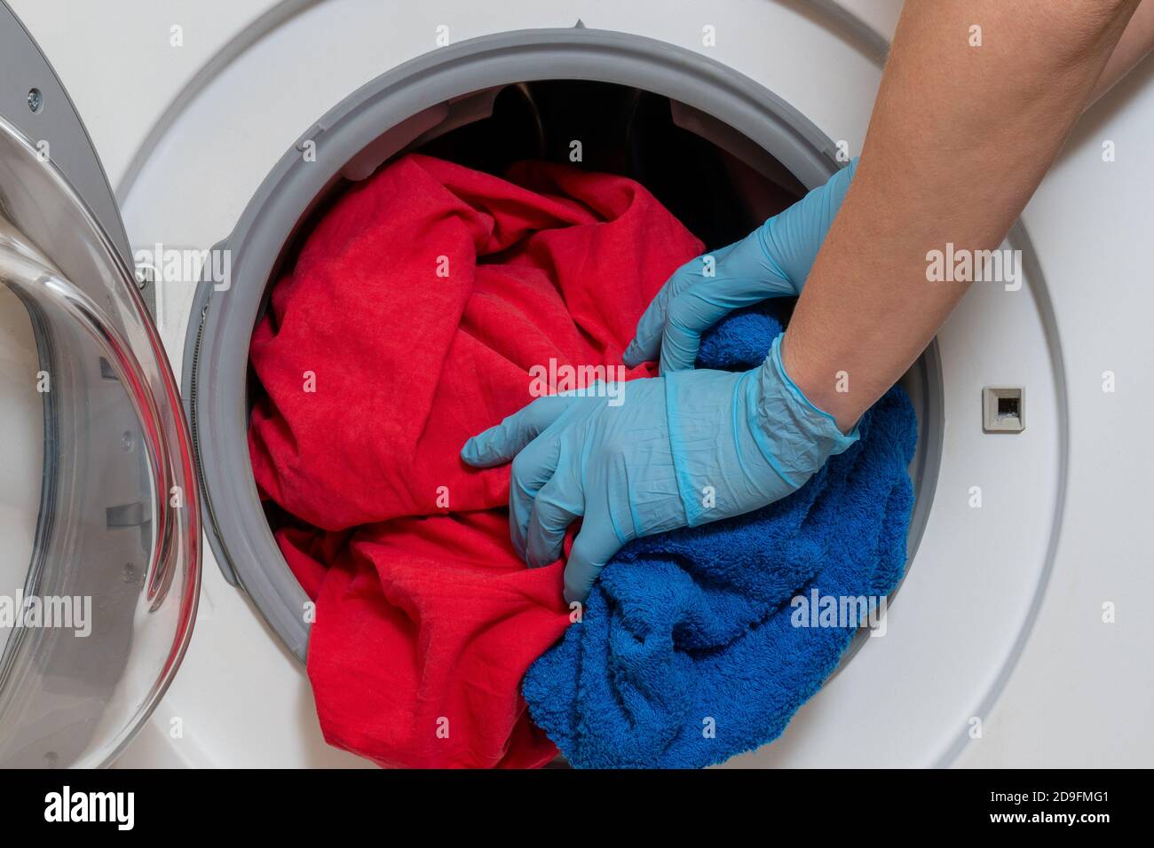 Loading bed linen into a household washing machine Stock Photo Alamy