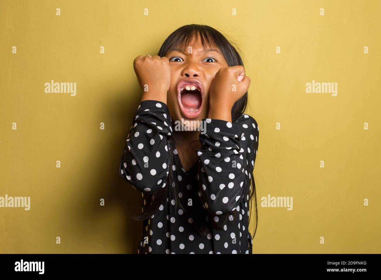 Asian little girl with punching fist to fight, aggressive and angry