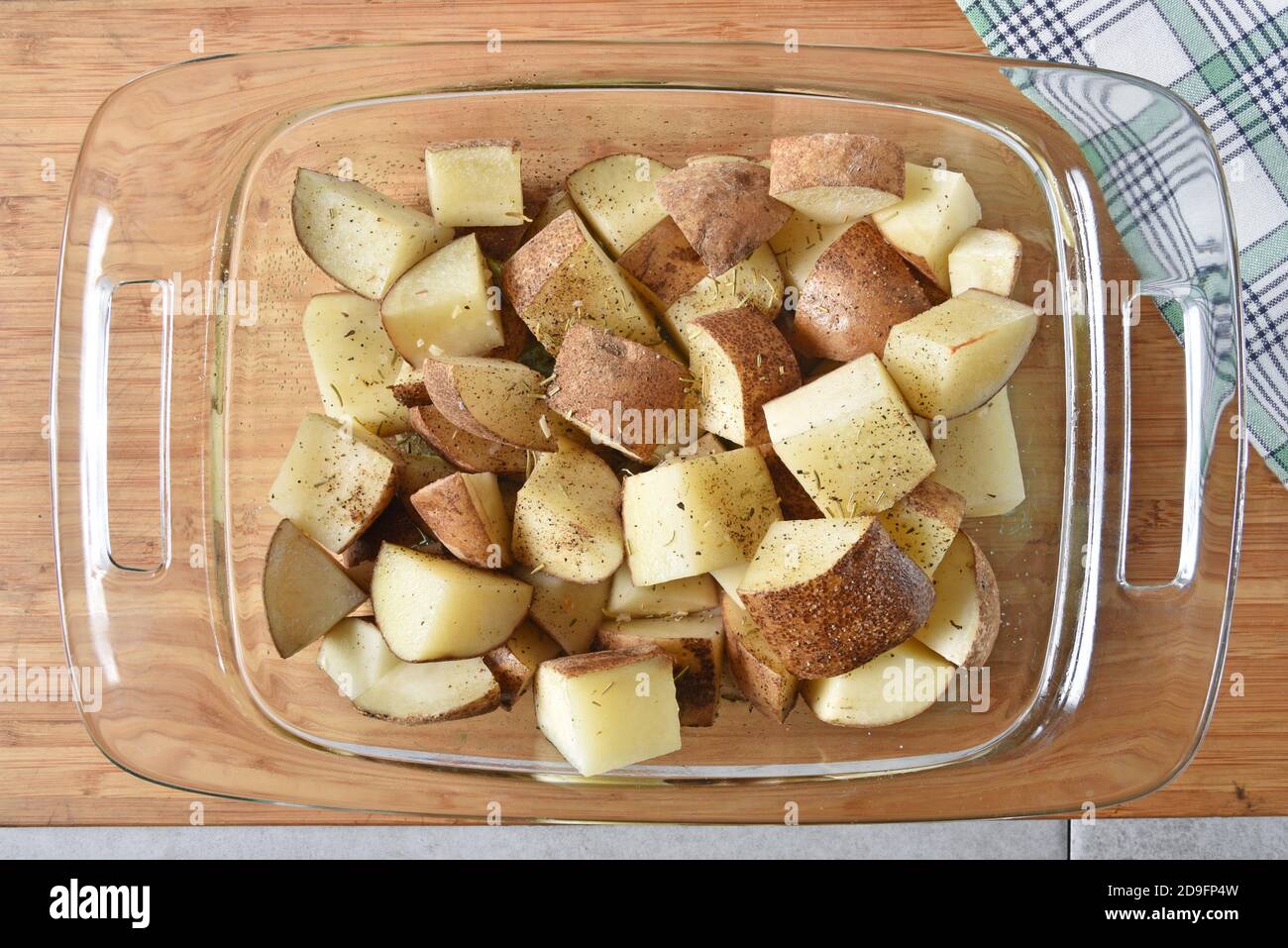 Overhead view of partially cooked cubed potatoes out of the oven to add