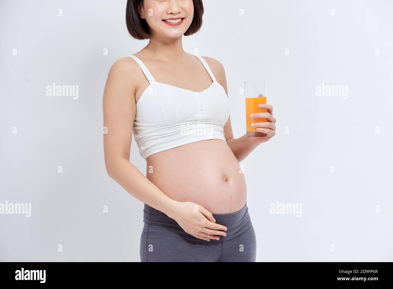 Young pregnant woman drinking orange juice with pleasure Stock Photo ...