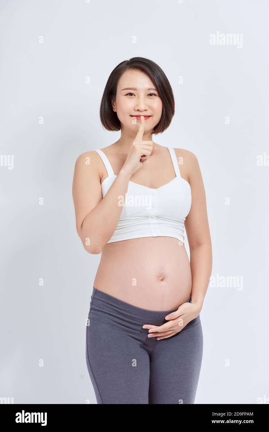 Young beautiful asian woman pregnant expecting baby asking to be quiet with finger on lips. silence and secret concept. Stock Photo
