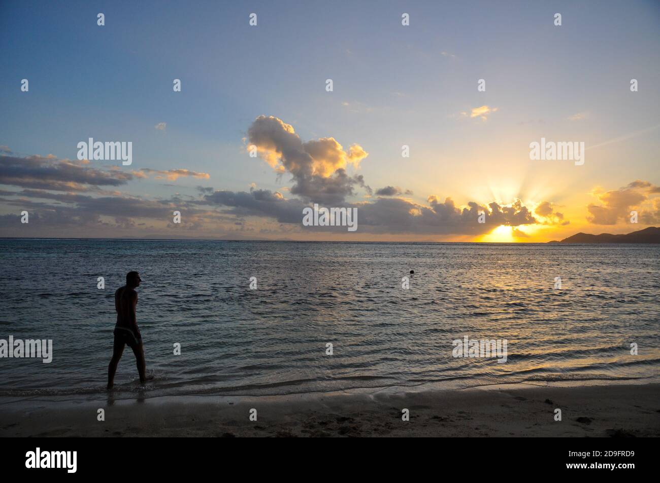Silhouette of a man at the beach at sunset Stock Photo - Alamy